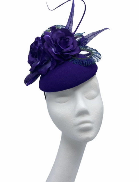 Purple headpiece with a stunning array of peacock feathers and purple flowers.