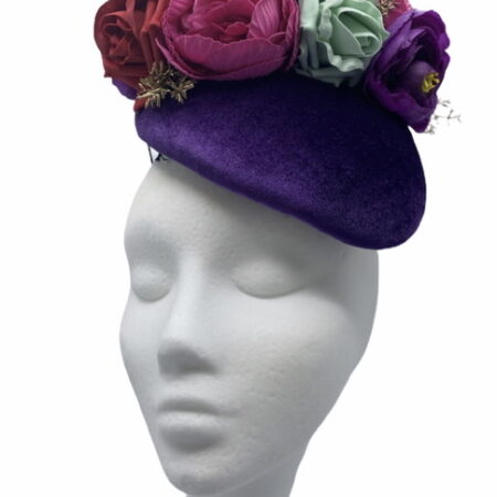 Purple velvet headpiece with an array of various coloured flowers.