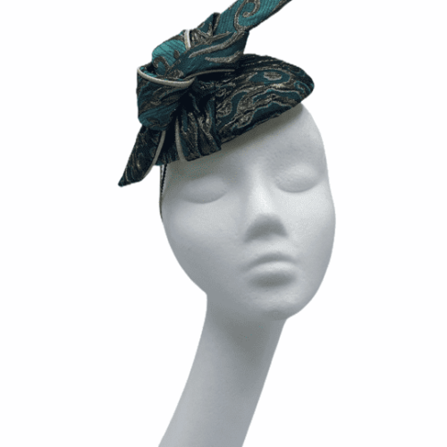 Small green/gold patterned headpiece with swirl in the same fabric and colour with gold trim detail to the swirl.