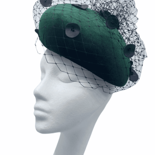 Green velvet teardrop headpiece with a black veiling detail with black leather spots.