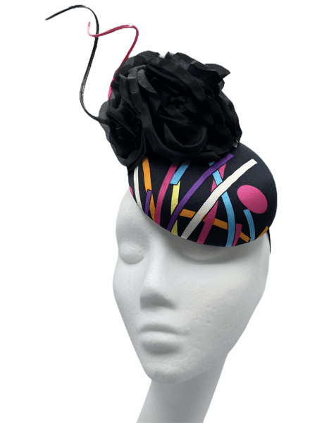 Smaller button headpiece with a multicoloured design to the base, finished with a black flower and black and pink quill.