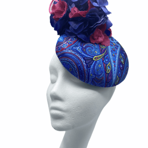 Paisley print pill box headpiece with flower and quill detail.