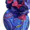 Paisley print pill box headpiece with flower and quill detail.