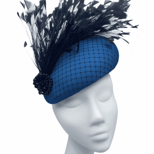 Teal large teardrop headpiece with black netting overlay and a spray of black ostrich feathers.