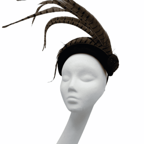 Black velvet bandeau headpiece with a spray of brown feathers.