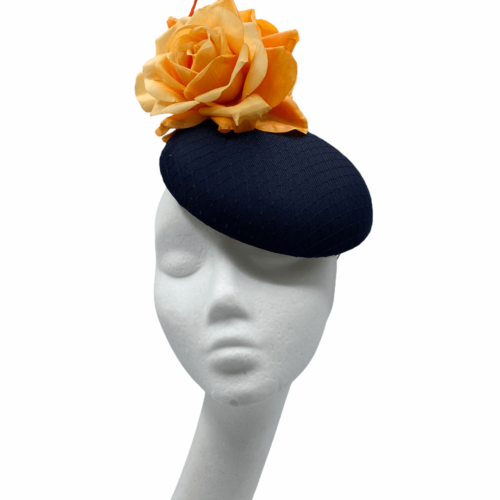 Navy base headpiece with net detailing cover, orange flower with orange quill detail.