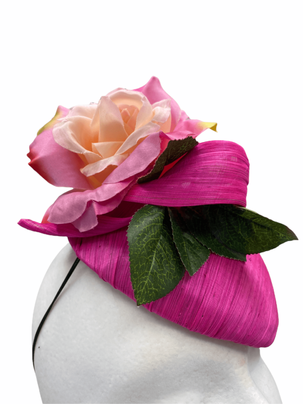 Pink raw silk headpiece with flower detail to top and finished with green leaf.
