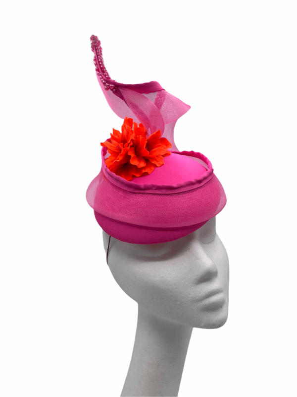 Pink headpiece with pink window swirl and finished with an orange flower to the centre.