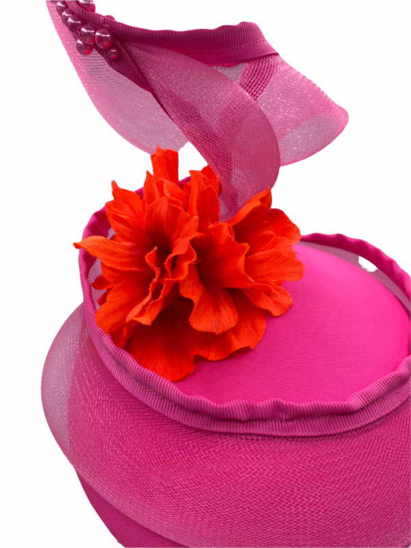 Pink headpiece with pink window swirl and finished with an orange flower to the centre.