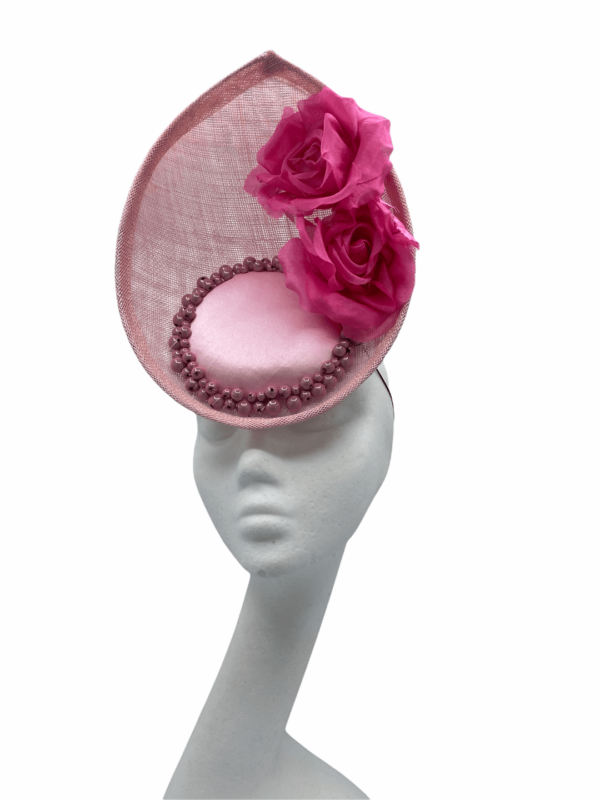 Pink frontal percher with pink satin centre surrounded by pink pearls, finished with 2 pink flowers to left side.