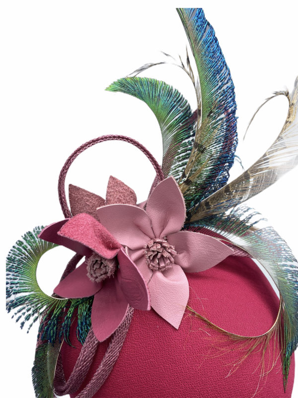 Pink headpiece with different tone pink leather flowers and peacock feather detail to finish.