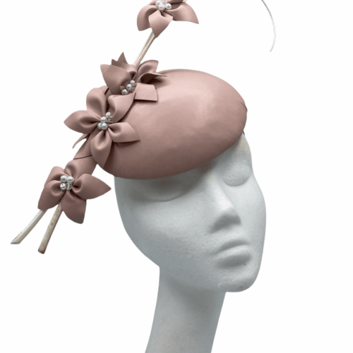 Pink leather headpiece with cream quills and leather petal flowers.