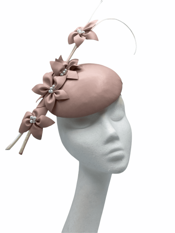 Pink leather headpiece with cream quills and leather petal flowers.