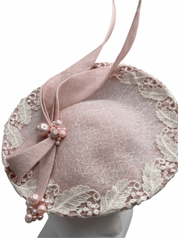 Pink side saucer with lace overlay around the entire headpiece, finished with pink swirl and pearl detail.
