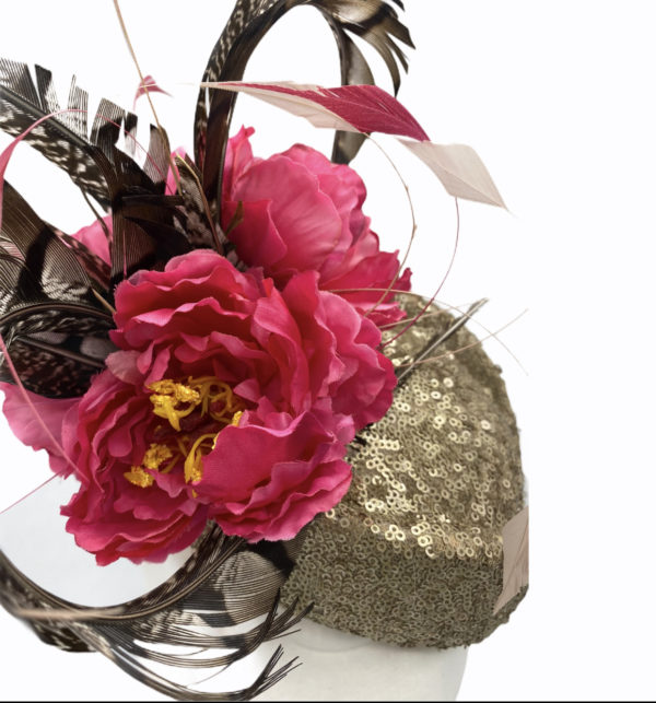 Gold sequinned headpiece with stunning feather and pink flower detail.