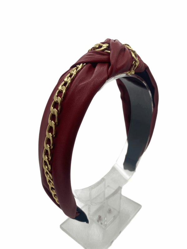 Burgundy faux leather headband with gold chain detail.