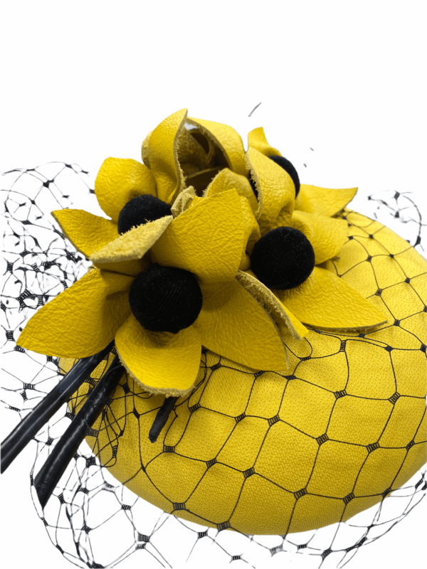 Yellow headpiece with black veiling and black centre flower detail.