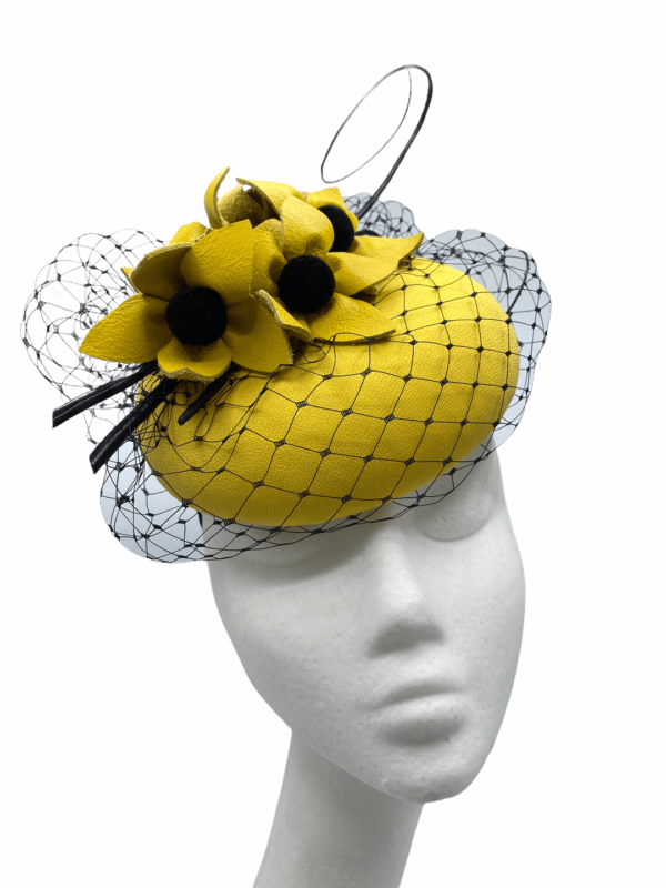 Yellow headpiece with black veiling and black centre flower detail.