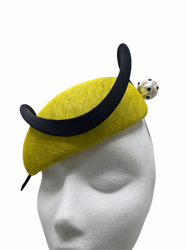 Yellow headpiece with structured swirl detail, small yellow pearl detail to the base of the swirl.