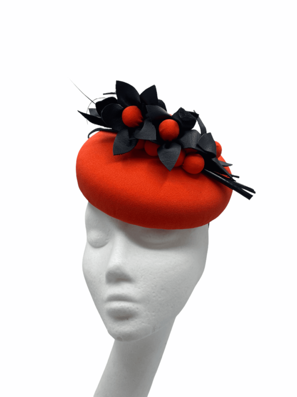 Orange headpiece with black flower detail.