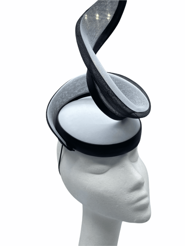 White leather headpiece with black trim detail and swirl structure to finish.