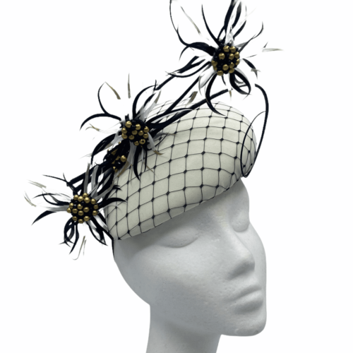 Cream/ivory base with black veiling overlay, finished with black/ivory feather with gold centre beading detail.