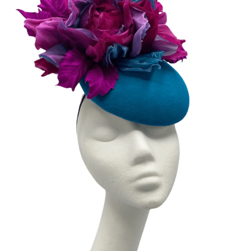 Teal felt base headpiece with pink and teal flower detail to the top.