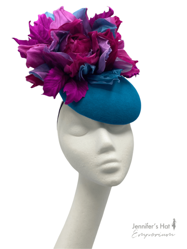 Teal felt base headpiece with pink and teal flower detail to the top.