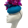 Teal felt base headpiece with pink and teal flower detail to the top.