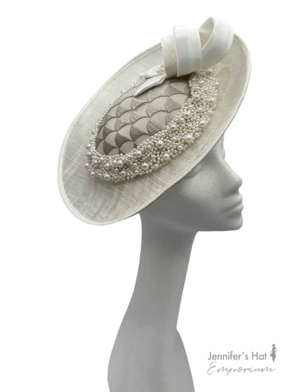 Ivory side saucer disc headpiece, ivory/taupe satin swirl detail to the top. Ivory headband with taupe patterned detail to the side surrounded with pearls.