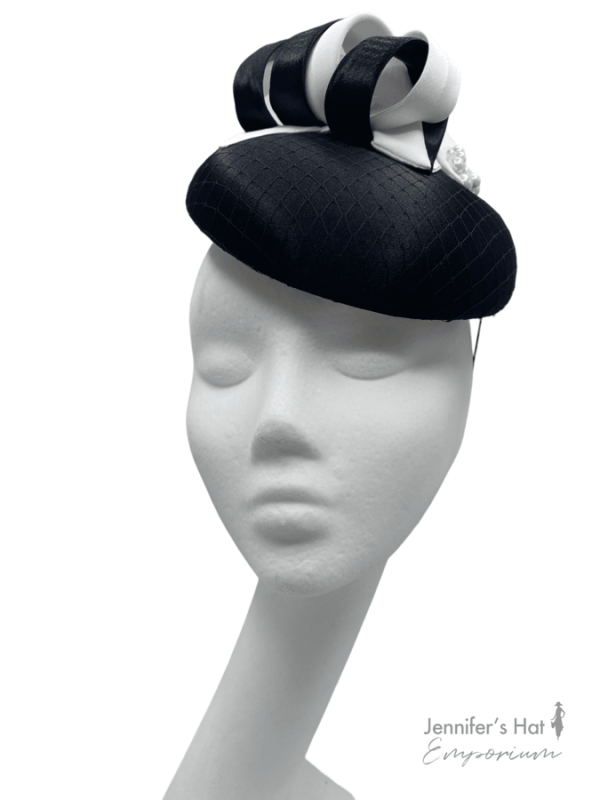 Black satin headpiece with black/white swirl detail and pearls to finish. 