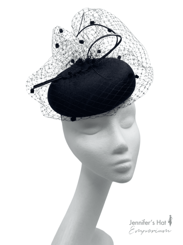 Black headpiece with black polka dot veiling detail to the top.