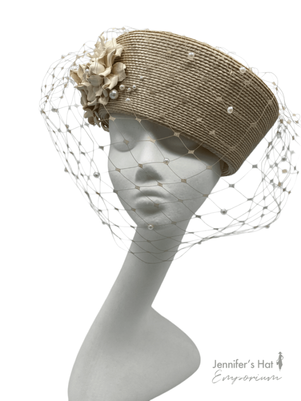 Beige coloured headpiece with pearl encrusted full face veiling.