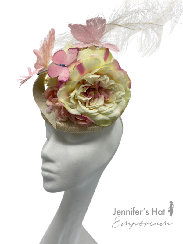 Cream base with cream flowers and beautiful pink butterflies with cream leather swirl detail. Large cream feather that rises up from the back of the headpiece.