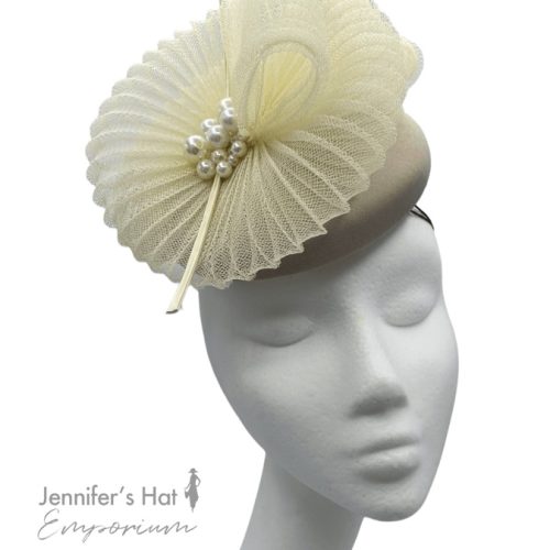 Taupe based headpiece with cream crin detail, finished with pearl decor and cream quill.