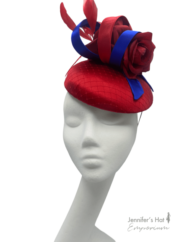 Stunning red satin headpiece with red flowers and royal blue swirl detail.
