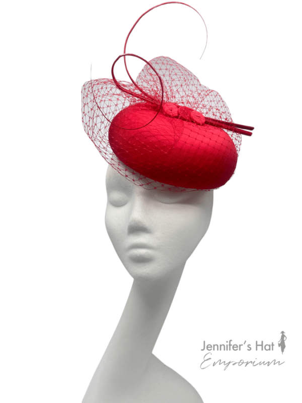 Stunning red pillbox headpiece with stunning red veiling and finished off with red quill detail.