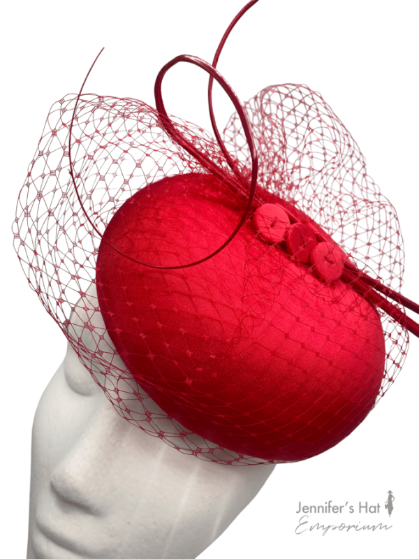 Stunning red pillbox headpiece with stunning red veiling and finished off with red quill detail.