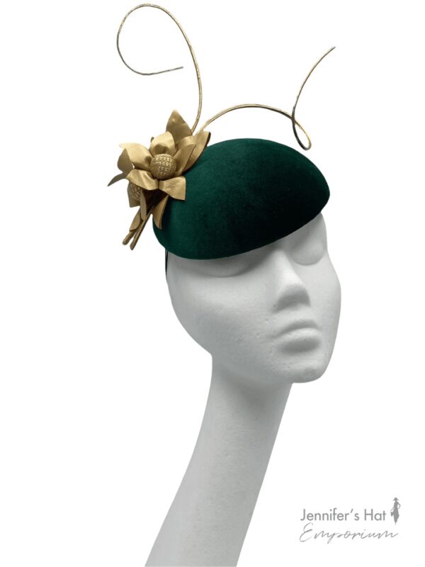 Green velvet hat with gold flower detail.