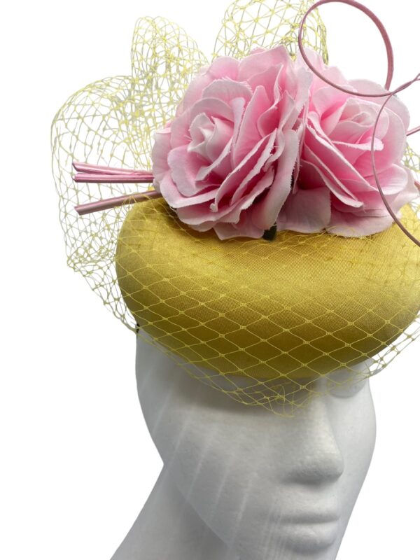 Yellow/mustard headpiece with stunning veiled detail finished with pink flowers.