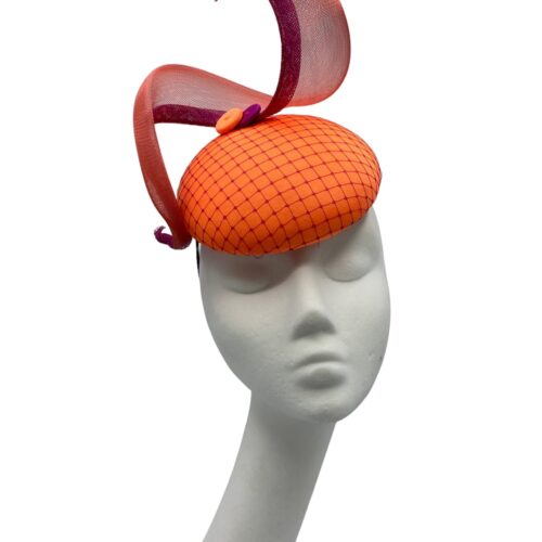 Tangerine coloured orange headpiece with stunning magenta pink overlay veiling to the base with matching swirl detail.