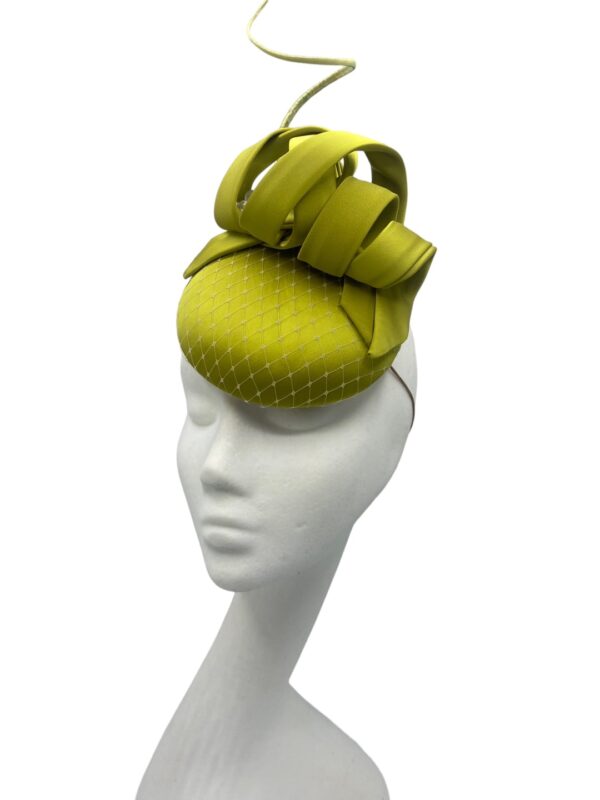 Small lime green satin headpiece with matching quill and pearl detail.