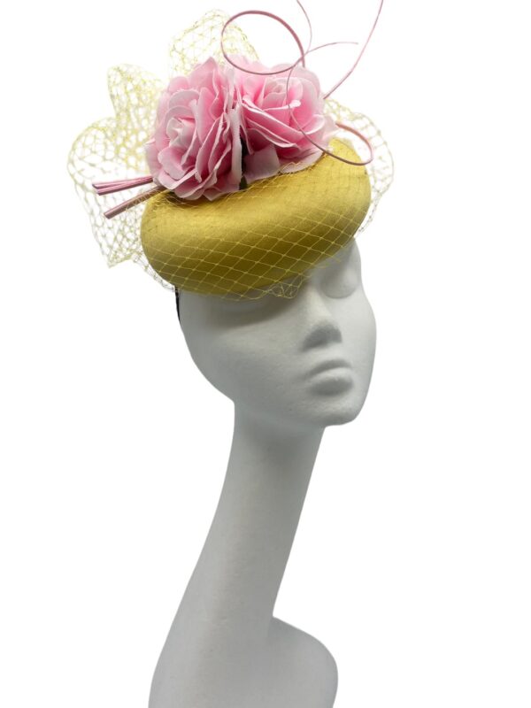 Yellow/mustard headpiece with stunning veiled detail finished with pink flowers.
