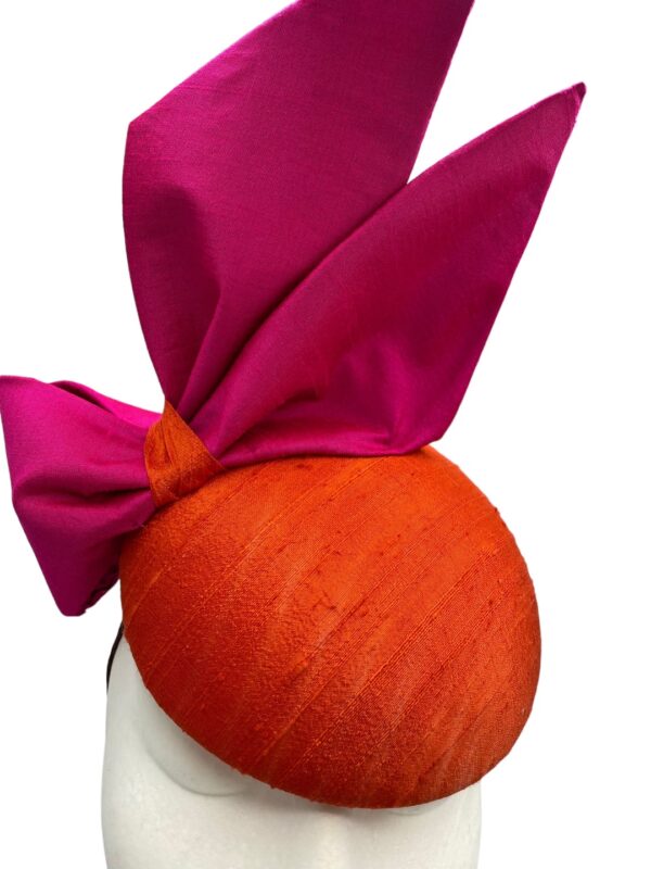 Orange raw silk headpiece with pink raw silk side bow.