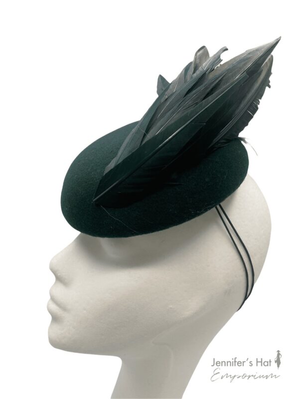 Beautiful forest green felt base headpiece with a gorgeous array of structured feather detail.