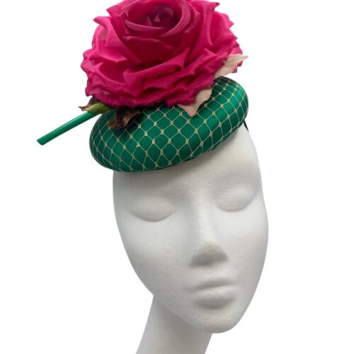 Emerald green satin headpiece with gold veiling overlay finished with a stunning fuchsia pink flower and green quill detail.