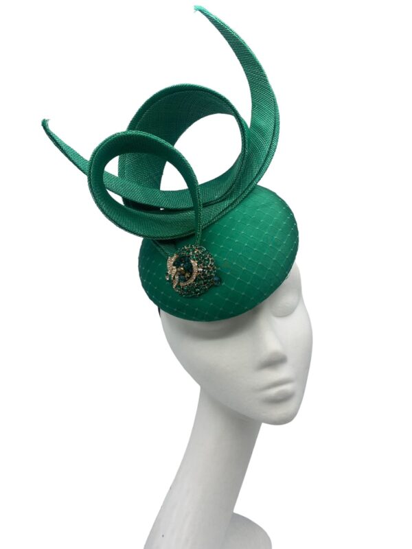 Emerald green pillbox with green swirl and jewelled detail to front.