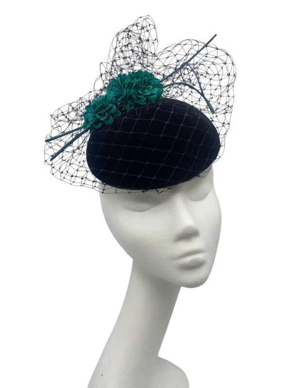 Black velvet headpiece with black veiling overlay and teal green flower detail to finish.