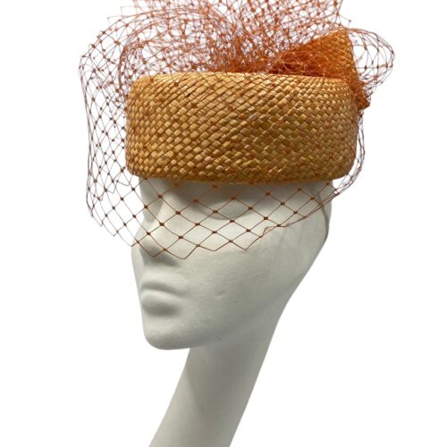 Orange veiled parasisal straw Jackie Onassis inspired headpiece with bow detail to the back.