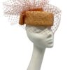 Orange veiled parasisal straw Jackie Onassis inspired headpiece with bow detail to the back.